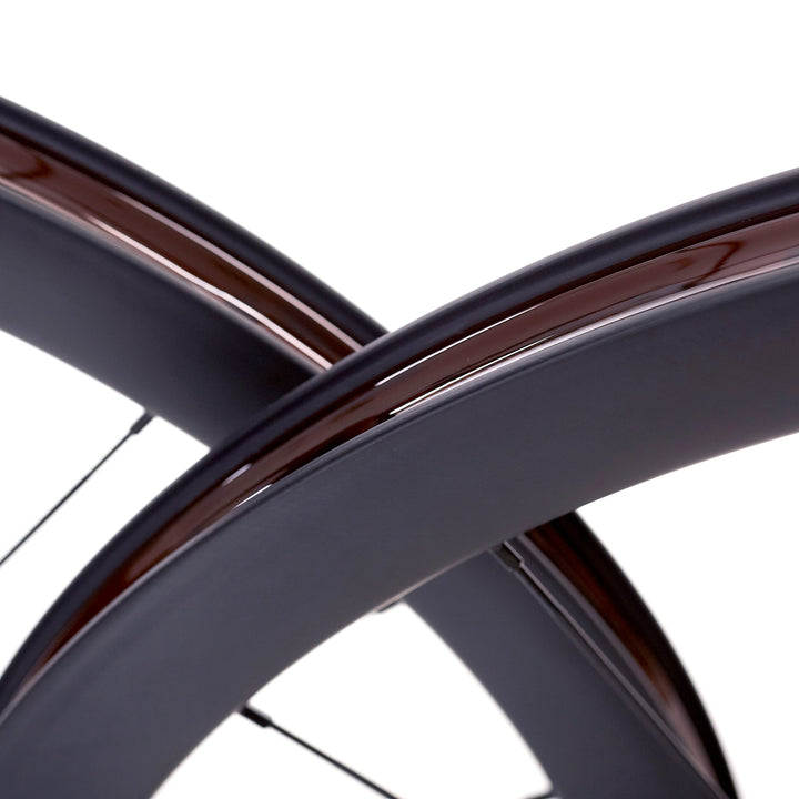 Detalle de dos llantas de carbono 40mm para gravel, tubelizadas con cinta, ancho interior de 25mm, tecnología Tubeless Ready que optimiza la tracción y comodidad en terrenos de grava y tierra.