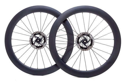 Par de ruedas de carbono 60mm para carretera con perfil aerodinámico, bujes Ratchet System y tecnología Tubeless Ready. El diseño de 60mm mejora la aerodinámica y reduce la resistencia al viento, ideal para mejorar la velocidad y estabilidad en recorridos largos