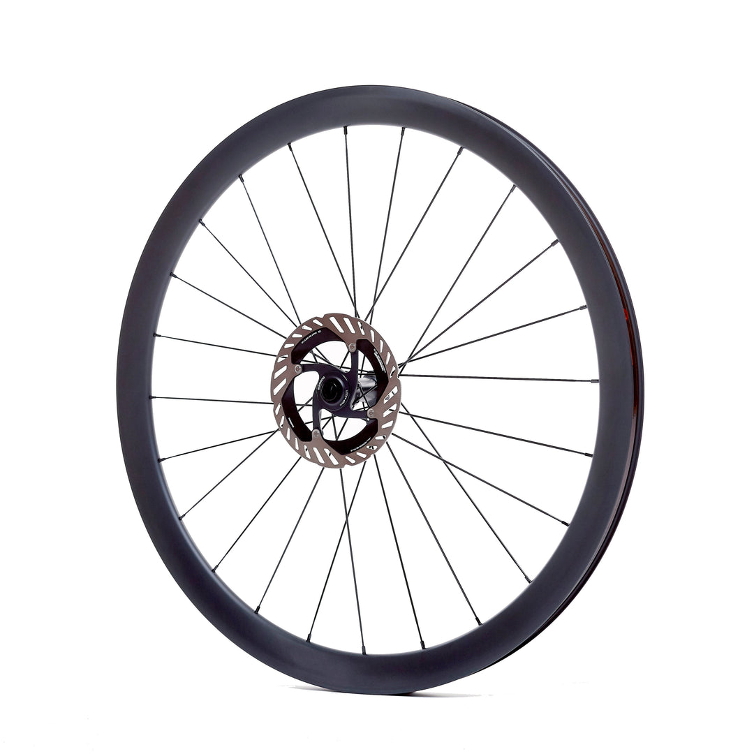 Rueda de carbono 40mm para carretera vista lateral, con perfil de 40mm que equilibra aerodinámica y maniobrabilidad. Bujes Ratchet System y ancho interno de 21.5mm para mayor estabilidad en recorridos largos.