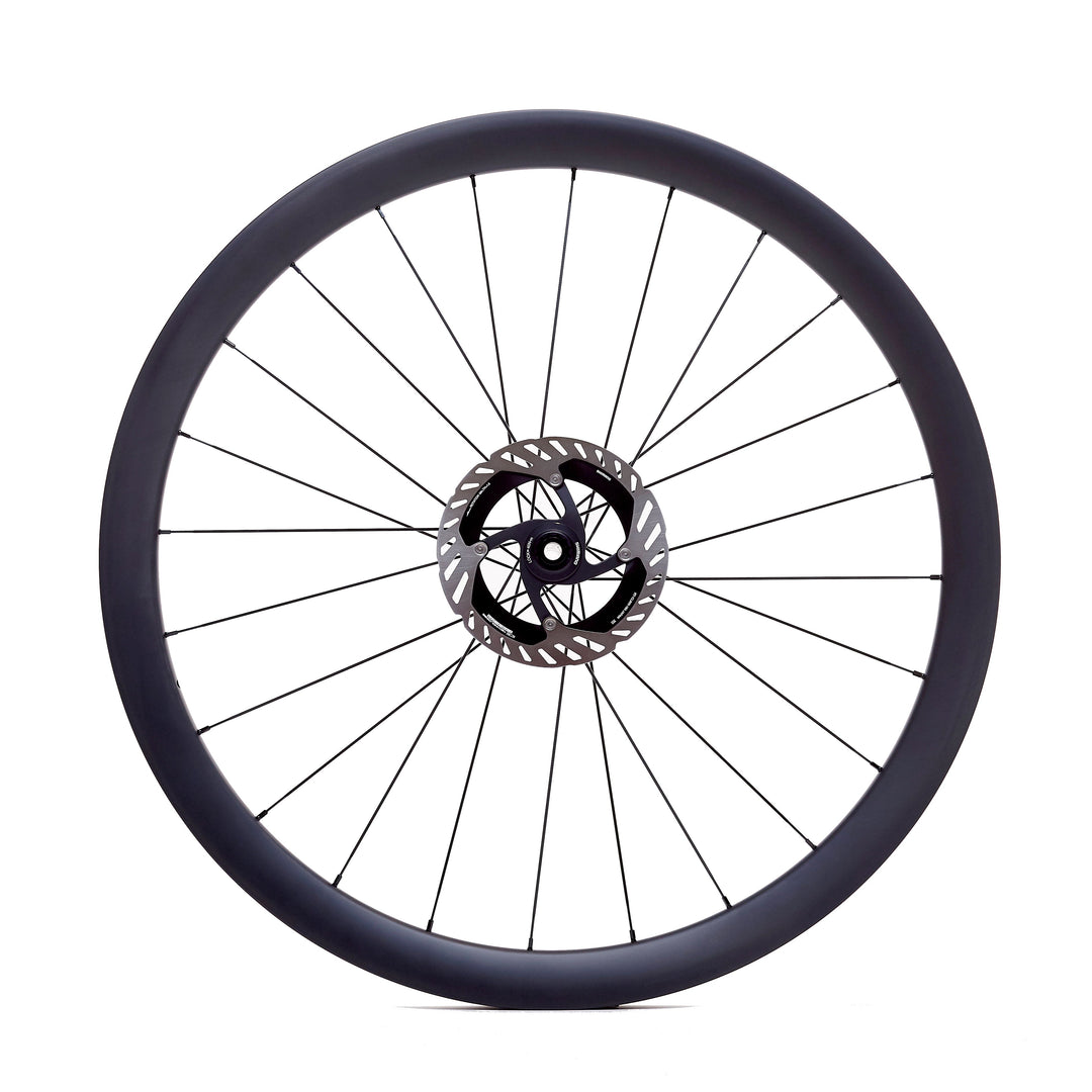 Rueda de carbono 40mm para gravel vista frontal, perfil aerodinámico que mejora la eficiencia en rodadura, tecnología Tubeless Ready y ancho interior de 24.5mm para un ajuste óptimo del neumático.
