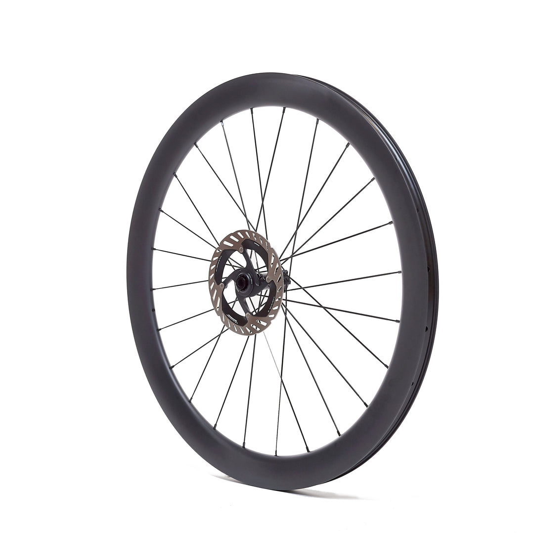 Rueda de carbono 50mm para carretera vista lateral, perfil de 50mm que optimiza la aerodinámica y la eficiencia en la rodadura. Bujes Ratchet System para una respuesta inmediata y tecnología Tubeless Ready para mayor agarre.